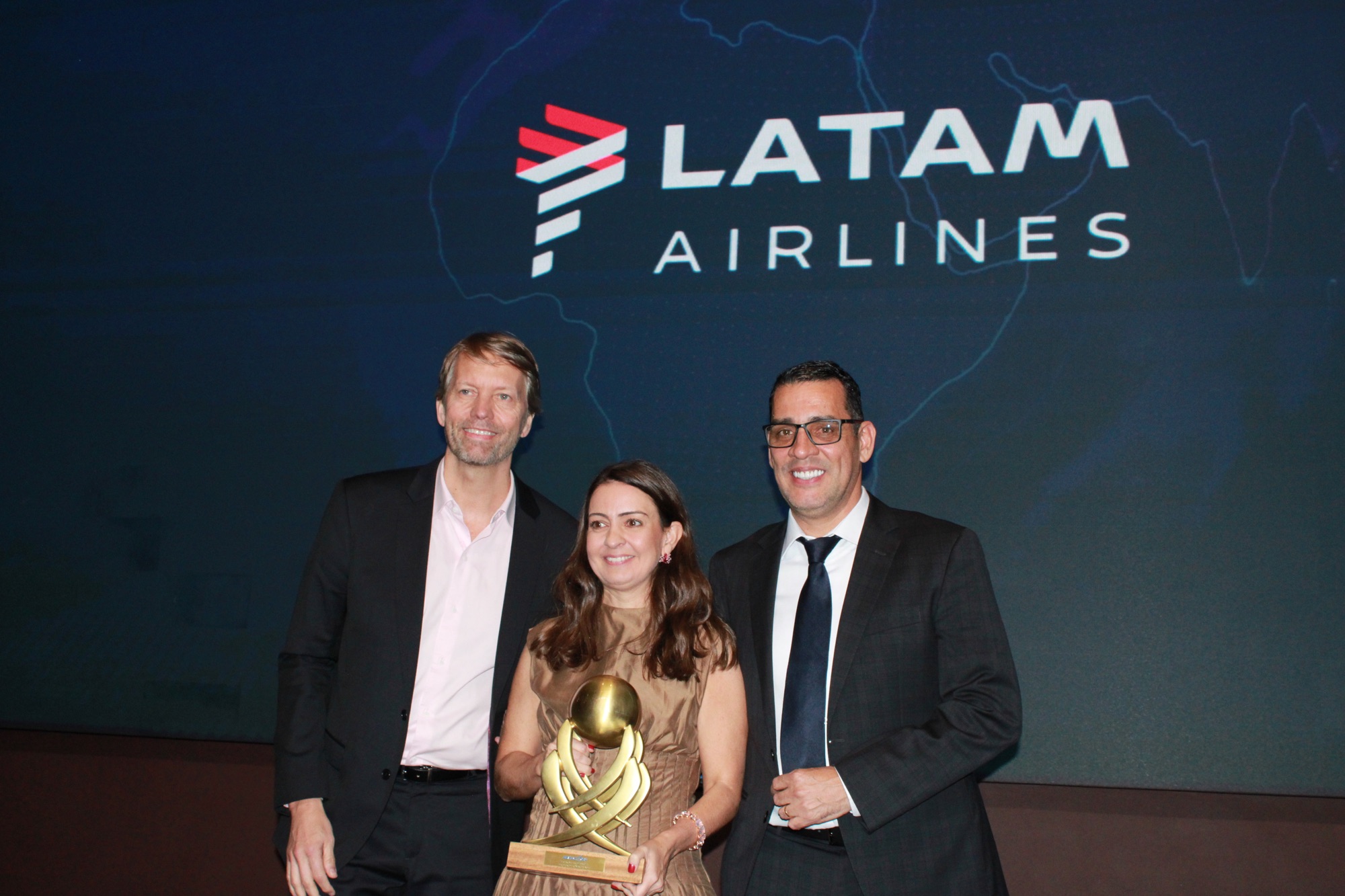 Jerome Cadier e Aline Mafra, da Latam, recebem o prêmio de 'Melhor Companhia Aérea Nacional' das mãos de Siderley Santos, da Abracorp (Giulia Jardim/M&E)