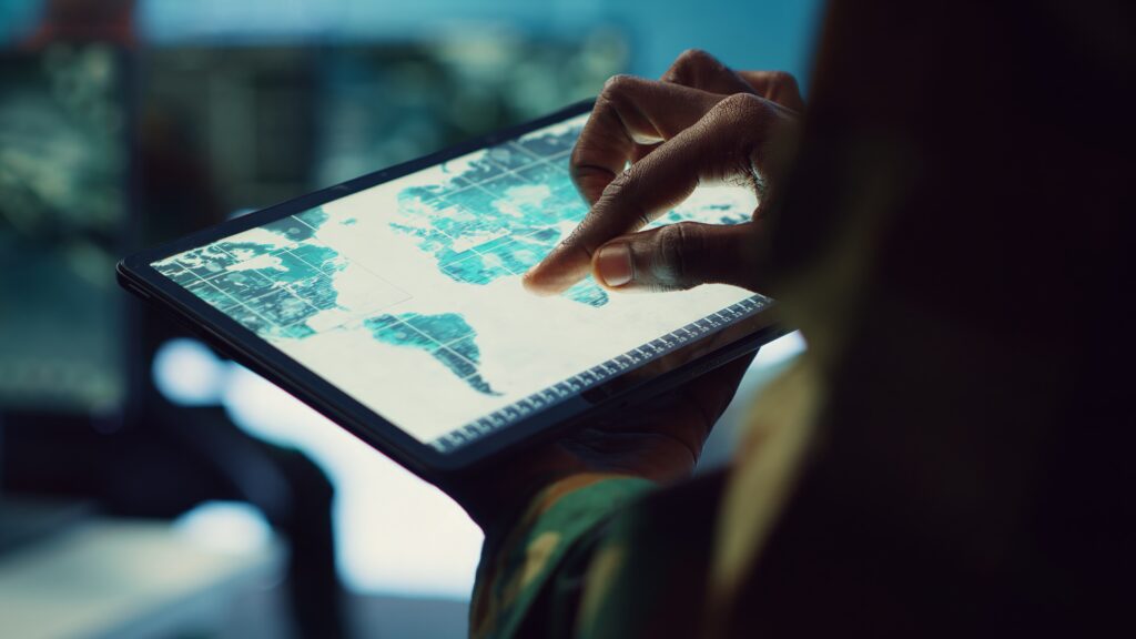 Inteligência Artificial no turismo: ameaça ou aliada dos profissionais do setor? 1 profissional de ti militar reune inteligencia da projecao mapa mundo 2 Inteligência Artificial no turismo: ameaça ou aliada dos profissionais do setor?