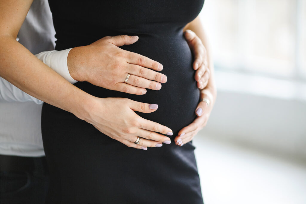 homem mantem as maos para barriga da mulher gravida vista lateral EUA podem barrar vistos de estrangeiros que viajam para dar à luz no país