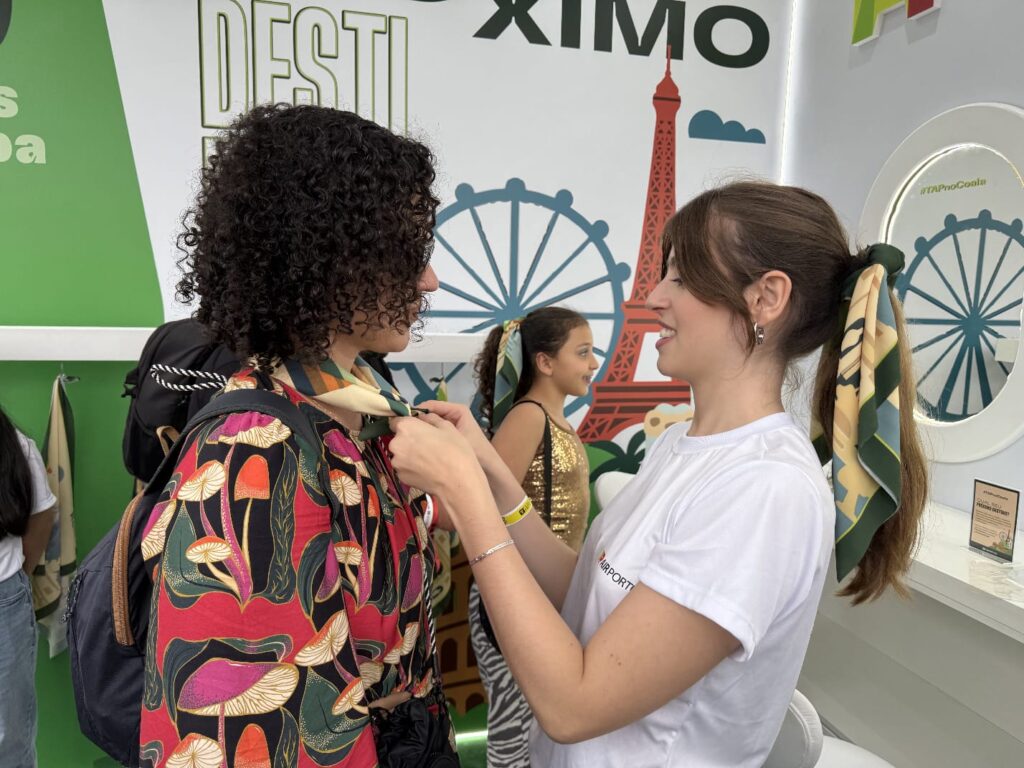 Estilista customizando lenco durante evento TAP Air Portugal conecta destinos europeus ao público brasileiro durante Coala Festival 2025